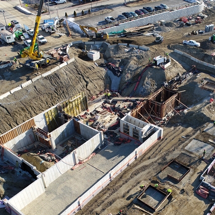 Civil Engineering and Permitting; aerial view of construction site and retaining walls and cranes