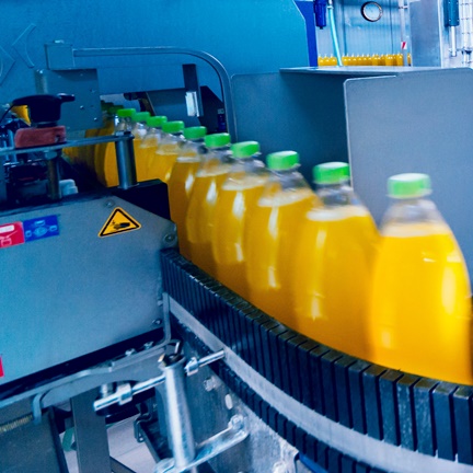 packaged juice bottles on a conveyer built to portray food packaging